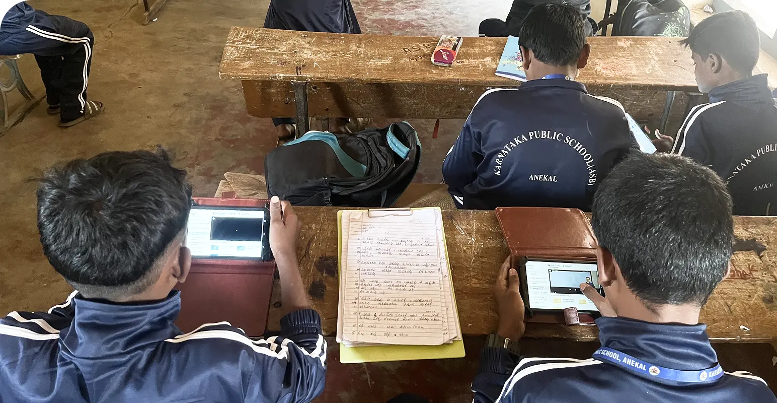 Students engaged in a blended learning environment at school, using notebooks alongside an offline digital content learning tablet