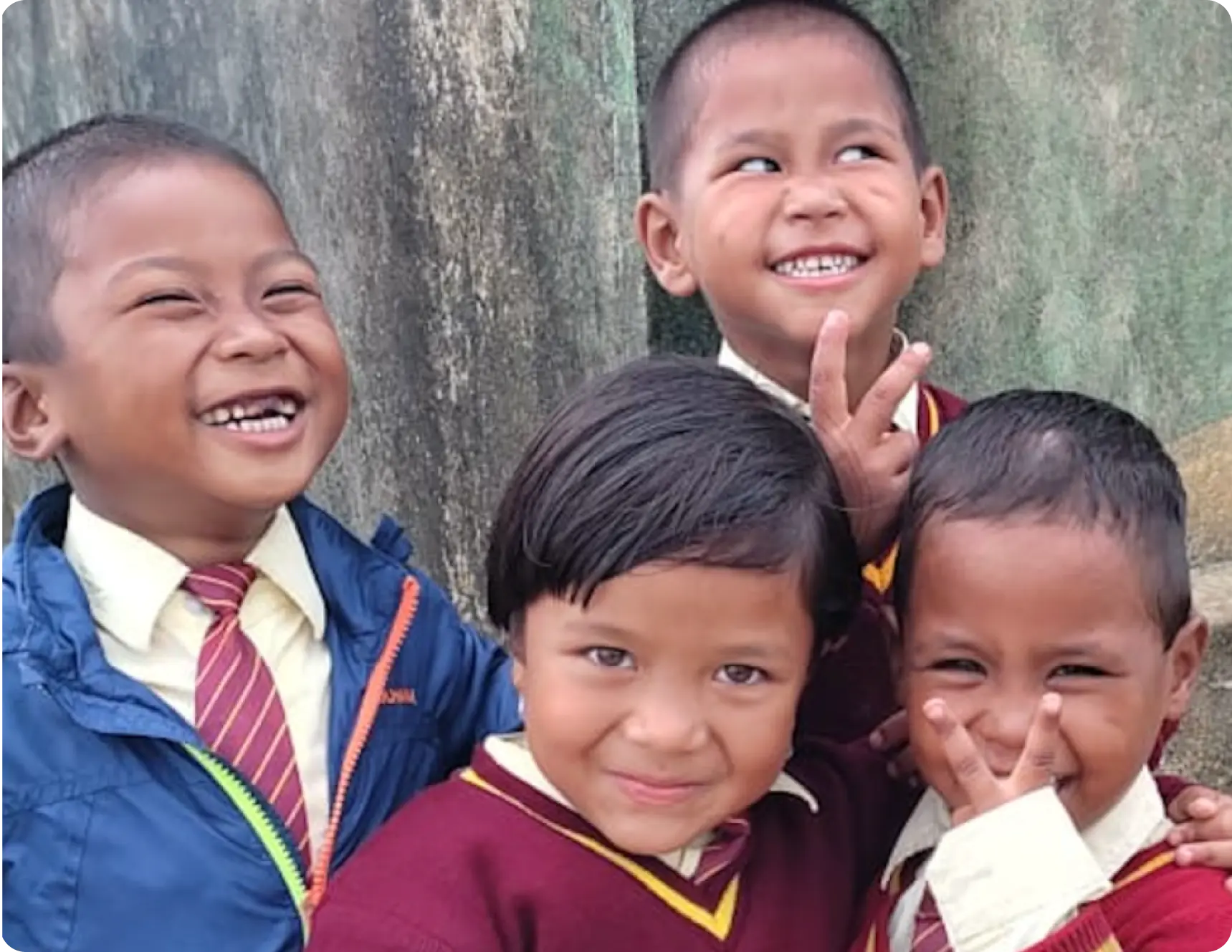 A group of primary school students in their school uniforms, smiling and expressing joy about being in school