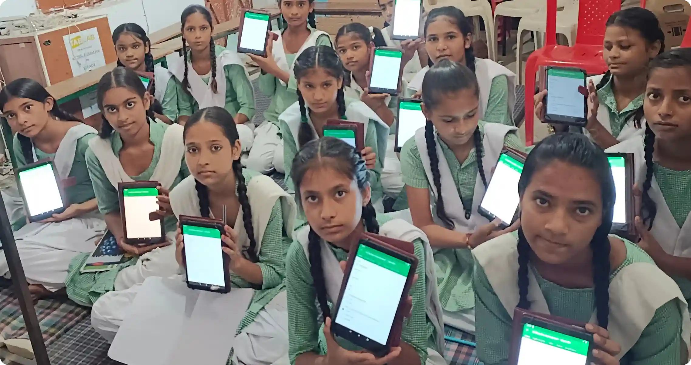 Girls showing learning tablets provided by an edtech NGO for girls education