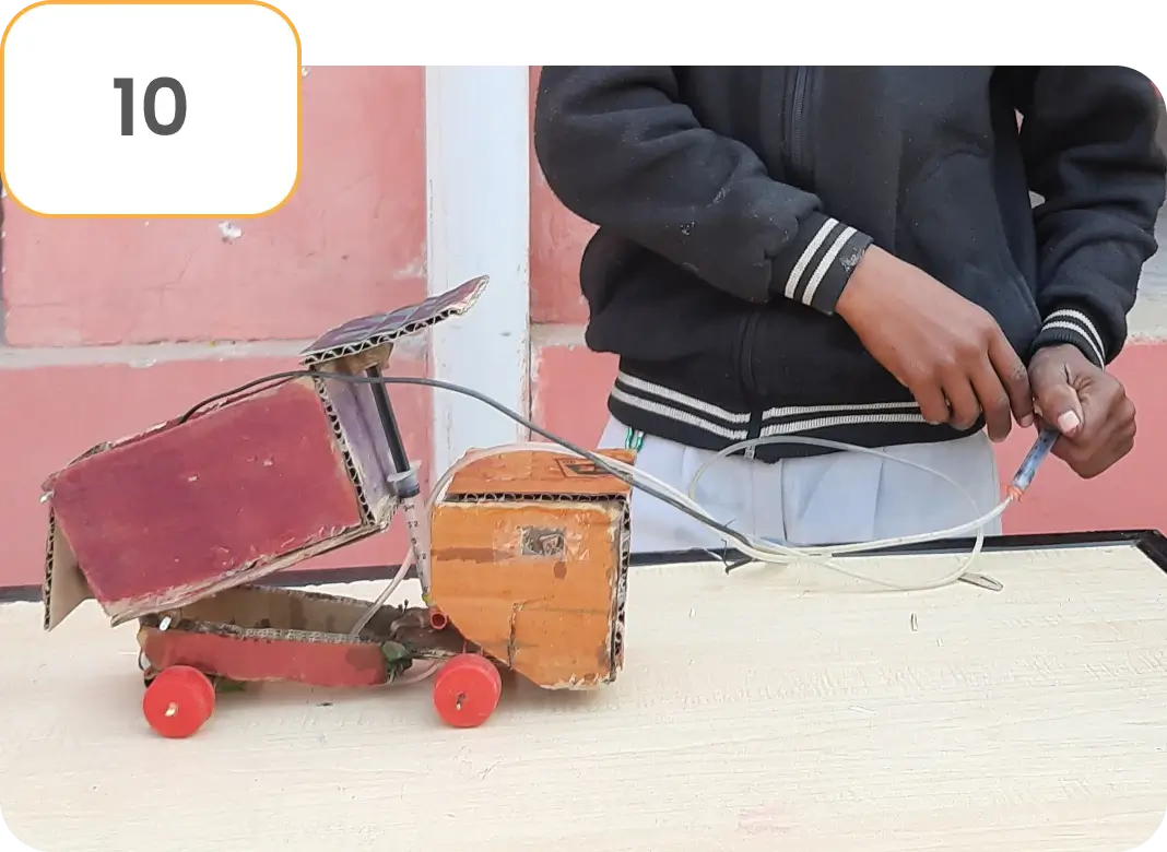 Students engaged in making a DIY project while watching activity-based video content on a learning platform provided through an education project, fostering hands-on and experiential learning