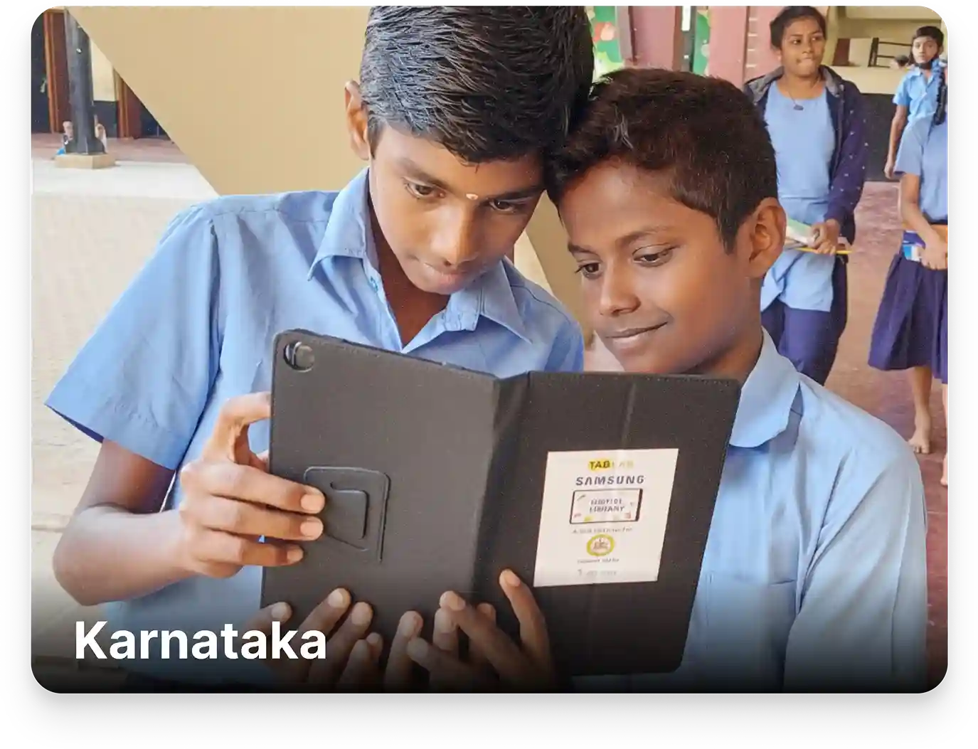 Students learning from Kannada Board-aligned digital content on tablets in an ICT lab setup at a school in Karnataka