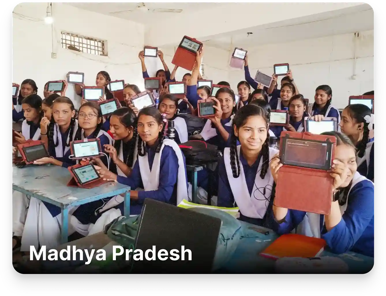 Students showcasing a tablet from a digital library setup featuring offline MP Board-aligned digital content