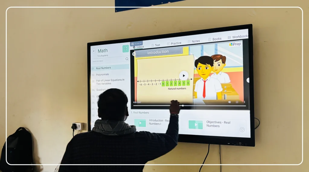 Teacher delivering a lesson using animated video content on an interactive flat panel for school education