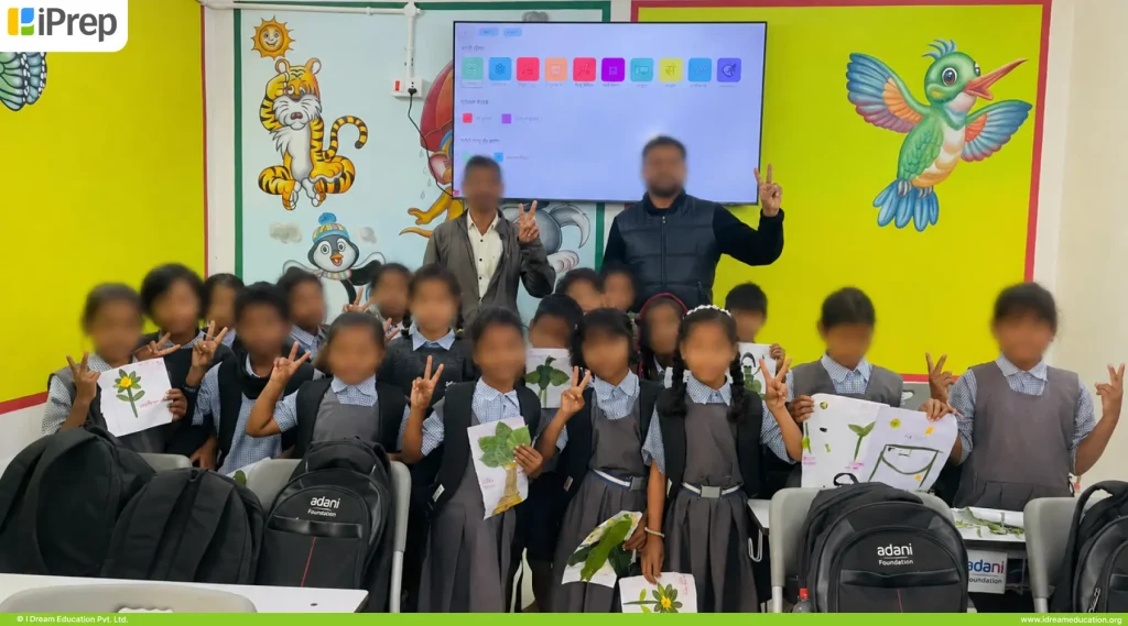 Happy children posing in front of offline smart class setup in a government school